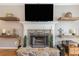 Close-up of a stone fireplace with a white mantel, floating wood shelves, and decorative accents at 2515 Little John Ct, Cumming, GA 30040