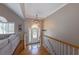 Inviting foyer with hardwood floors, stairs, a decorative chandelier, and a view of the living room at 2515 Little John Ct, Cumming, GA 30040