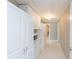 Hallway with white cabinets and appliances for extra storage, complete with tile flooring for easy cleaning at 2515 Little John Ct, Cumming, GA 30040