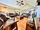 Well-lit living room with hardwood floors, leather seating, and an open layout to the dining area at 2515 Little John Ct, Cumming, GA 30040