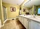 This main bathroom features double sinks, a framed mirror, and a large tub/shower combo at 2515 Little John Ct, Cumming, GA 30040