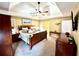 This main bedroom boasts a trey ceiling, a ceiling fan, and well-coordinated wooden furniture at 2515 Little John Ct, Cumming, GA 30040