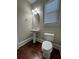 Powder room featuring a pedestal sink, toilet, and dark wood flooring, blending classic design with functionality at 2822 Salem Oak Way, Duluth, GA 30096