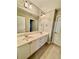 Bathroom featuring a double sink vanity, neutral tile flooring, and ample lighting at 2822 Salem Oak Way, Duluth, GA 30096