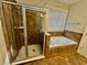 A tiled bathroom features a separate shower and tub under a window, providing a refreshing retreat at 2822 Salem Oak Way, Duluth, GA 30096