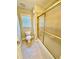 Well-lit bathroom features a shower with glass doors and a toilet with a window at 2822 Salem Oak Way, Duluth, GA 30096