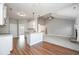 Open floor plan featuring modern kitchen, plush living room carpet, and a cozy stone fireplace at 5995 Crowley Dr, Douglasville, GA 30135