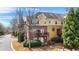 Aerial view of townhome with a brick and siding exterior, mature trees, two balconies, and landscaping at 928 Boudreau Ct, Atlanta, GA 30328