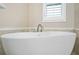 Close up of a white, standalone bathtub with brushed nickel fixtures at 928 Boudreau Ct, Atlanta, GA 30328