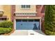 Attached garage featuring a stylish blue door, complemented by landscaped shrubs and plants at 928 Boudreau Ct, Atlanta, GA 30328