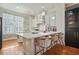 Modern kitchen with white cabinets, stone backsplash, and a stylish island with seating at 928 Boudreau Ct, Atlanta, GA 30328
