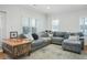 Spacious living room with large sectional couch, area rug, wood accent table, and bright windows at 928 Boudreau Ct, Atlanta, GA 30328
