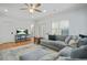 Open concept living room with hardwood flooring, oversized couch, and ceiling fan with light at 928 Boudreau Ct, Atlanta, GA 30328