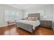 Spacious main bedroom with large windows, tray ceiling, hardwood floors, and a bed with gray headboard at 928 Boudreau Ct, Atlanta, GA 30328