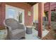 Covered patio with rocking chairs and small table, brick wall, and a view of the backyard at 928 Boudreau Ct, Atlanta, GA 30328