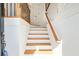Well-lit staircase featuring hardwood steps, white risers, and a decorative railing leading upstairs at 928 Boudreau Ct, Atlanta, GA 30328
