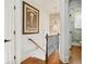 Hall landing with decorative picture, stairway with rail and view of stone accent wall in bath at 928 Boudreau Ct, Atlanta, GA 30328