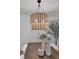 A two-tiered woven chandelier hanging over a modern dining room table, with a faux olive tree in the corner at 1468 Briarwood Ne Rd # 502, Brookhaven, GA 30319