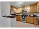 Well-lit kitchen with stainless steel appliances, wooden cabinets, and tile floor at 1468 Briarwood Ne Rd # 502, Brookhaven, GA 30319