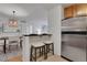 Modern kitchen featuring breakfast bar, stainless steel refrigerator, and view into dining room at 1468 Briarwood Ne Rd # 502, Brookhaven, GA 30319