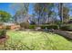 Green backyard featuring a shed or playhouse bordered by landscaping and stone walls at 218 Garland Ave, Decatur, GA 30030