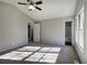 Bright bedroom featuring a ceiling fan and an ensuite bathroom at 63 Colette Ct, Douglasville, GA 30134