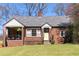 Charming brick home with a well-manicured lawn and cozy front porch at 1328 Briarwood Ne Dr, Atlanta, GA 30306