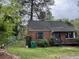 Exterior view of brick home with fenced yard, shrubs, and storm door at 3095 Rainbow Dr, Decatur, GA 30034