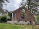 Rear exterior view of brick home with fenced yard and partial basement at 3095 Rainbow Dr, Decatur, GA 30034