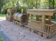 Wooden train play structure on the playground with a railroad crossing sign for imaginative play at 3841 Admiral Dr, Atlanta, GA 30341