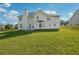 Expansive backyard with lush green grass and the rear of the house including the windows and roof at 93 Carriage Lake Dr, Stockbridge, GA 30281