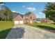 Brick home featuring a long driveway and lush green lawn at 93 Carriage Lake Dr, Stockbridge, GA 30281