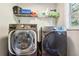 Bright laundry room featuring modern washer and dryer units with storage shelves above at 93 Carriage Lake Dr, Stockbridge, GA 30281