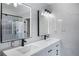 Bright bathroom with double vanity, illuminated mirrors, modern fixtures, and marble-patterned tile at 3521 Kittery Dr, Snellville, GA 30039