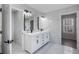 Bright bathroom featuring a double vanity, illuminated mirrors, black fixtures and marble-patterned tile at 3521 Kittery Dr, Snellville, GA 30039