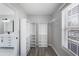 Walk-in closet featuring custom shelving, modern lighting, and wood-look flooring adjacent to the bathroom at 3521 Kittery Dr, Snellville, GA 30039