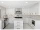 Well-lit kitchen featuring stainless steel appliances, white cabinetry, a kitchen island, and modern countertops at 3521 Kittery Dr, Snellville, GA 30039