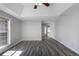 Light-filled main bedroom featuring wood-look flooring and a tray ceiling at 3521 Kittery Dr, Snellville, GA 30039