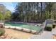 Community tennis court surrounded by tall trees and fencing, promoting active living at 566 Trillum Sw Ct, Marietta, GA 30008