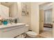 Bathroom features a white sink, tiled backsplash, round mirror, and adjacent doorway to another room at , Atlanta, GA 30318