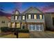 Charming two-story home with stone accents, a cozy front porch, and mature landscaping under a colorful dusk sky at , Atlanta, GA 30318