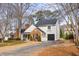 Charming home with a brick accent, well-manicured landscaping, and a long driveway leading to a one-car garage at 302 Roswell Green Ln, Roswell, GA 30075