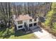 Aerial view of a two story house with a nice sized yard and many trees at 5075 S Woodbridge Trl, Stone Mountain, GA 30088