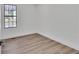 Bedroom featuring wood look flooring, a window, and fresh white paint at 5075 S Woodbridge Trl, Stone Mountain, GA 30088