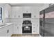 Modern kitchen with stainless steel appliances, white cabinetry, and solid surface countertops at 5075 S Woodbridge Trl, Stone Mountain, GA 30088