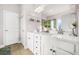 Bright bathroom with dual sinks, white cabinets, and a large framed mirror at 6441 Oakhurst Pl, Fairburn, GA 30213