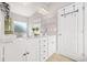 Bright bathroom with a double sink vanity, white cabinets, and modern decorative shelves at 6441 Oakhurst Pl, Fairburn, GA 30213