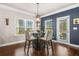 Bright dining area with a round table, bar seating, and natural light streaming through the windows at 6441 Oakhurst Pl, Fairburn, GA 30213