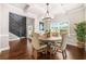 Bright dining room featuring a modern chandelier, hardwood floors, and a staircase with decorative wall trim at 6441 Oakhurst Pl, Fairburn, GA 30213