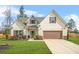 Charming two-story home featuring a manicured lawn, two car garage, and inviting front entrance at 6441 Oakhurst Pl, Fairburn, GA 30213
